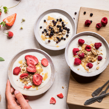 Gefriergetrocknete Früchte sind auf drei Joghurt-Bowls abgebildet